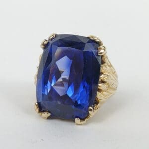 Gold ring with large blue gemstone.