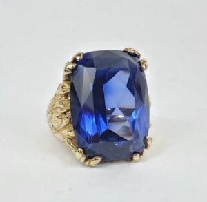 Gold ring with large blue gemstone.