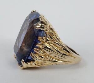Gold ring with large blue gemstone.