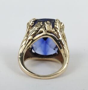 Gold ring with large blue gemstone.