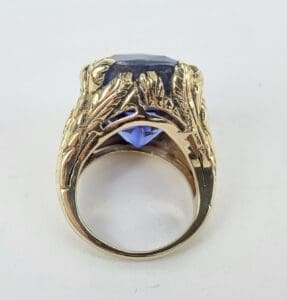 Gold ring with large blue gemstone.