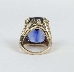 Gold ring with blue gemstone center.