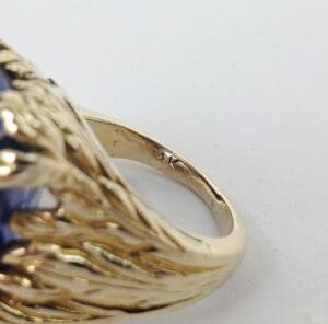 Gold ring with intricate design and gemstone.