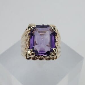 Gold ring with a purple gemstone.