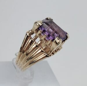 Gold ring with large purple gemstone.