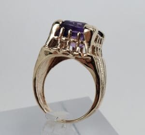 Gold ring with a purple gemstone.