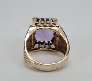 Gold ring with purple gemstone, back view.