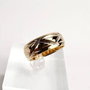 Gold ring with engraved star pattern.
