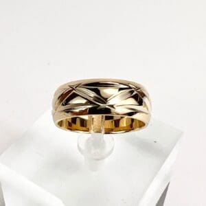 Gold ring with engraved star pattern.