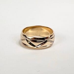 Gold ring with engraved geometric design.