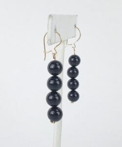 Gold hook earrings with black beads.