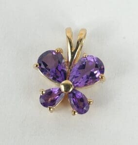 Purple gemstone butterfly pendant on white background.