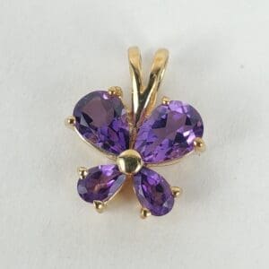 Purple gemstone butterfly pendant on white background.