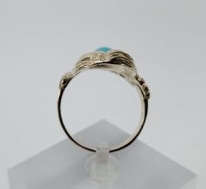 Gold ring with turquoise stone display.