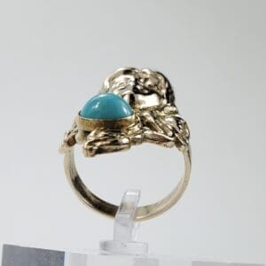 Gold ring with turquoise cabochon stone.