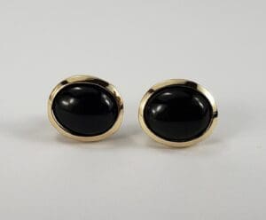 Gold oval cufflinks with black stones.