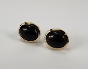 Gold earrings with black oval stones.