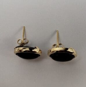 Gold earrings with black stones on display.