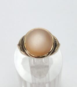 Gold ring with a round, opaque stone.