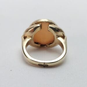 Gold ring with an orange gemstone setting.