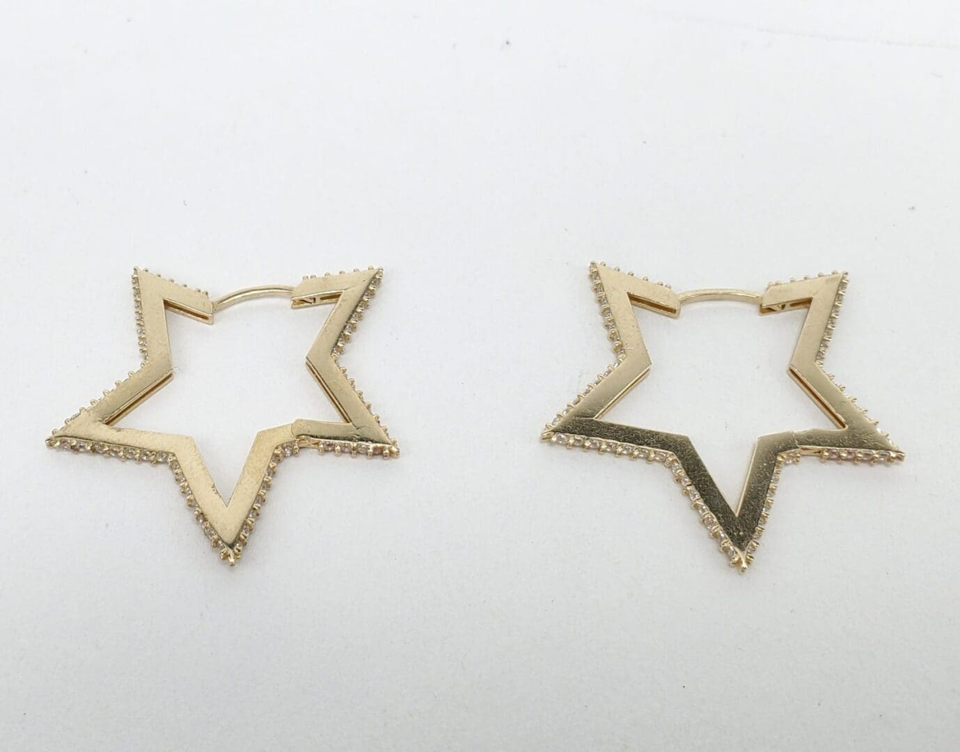 Gold star-shaped hoop earrings.