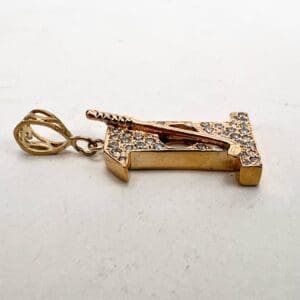 Gold cricket bat pendant with diamonds.