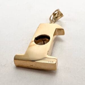 Gold whistle pendant with 14K engraving.