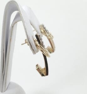 Gold hoop earrings on display stand.