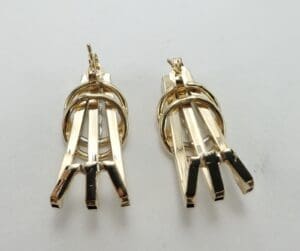 Gold geometric dangle earrings on display.