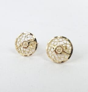 Gold filigree circular earrings on display.