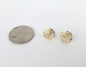 Gold earrings next to a quarter coin.