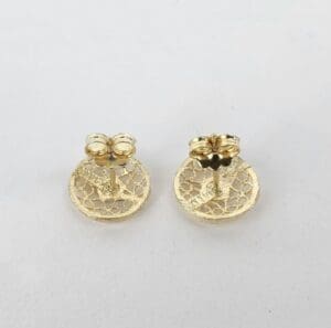 Gold filigree earrings on white background.