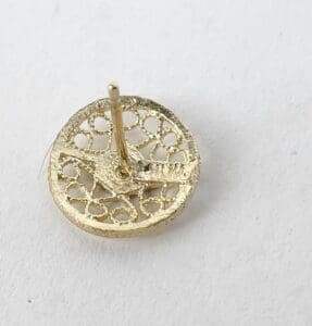 Gold circle earring with intricate design.