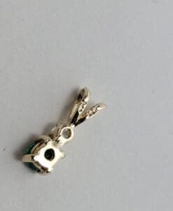 Silver pendant with green gemstone on white.