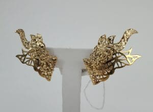 Gold dragon-shaped earrings on display stand.