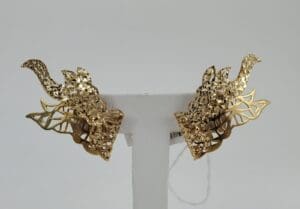 Intricate gold earrings with leaf design.
