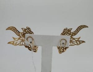 Intricate dragon-themed gold earrings display.