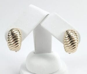 Gold ribbed clip-on earrings on display.