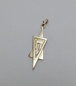 Gold pendant with geometric design and symbol.