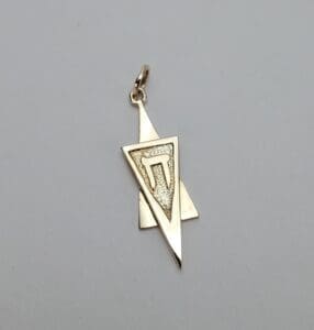 Geometric gold pendant with triangular design.