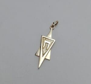 Gold triangular pendant with Hebrew letter.