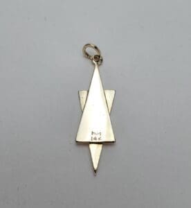 Gold triangular pendant with loop attachment.