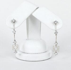 Silver earrings with geometric diamond accents.