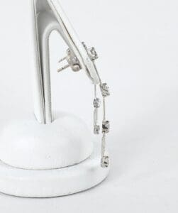 Silver earrings on white display stand.