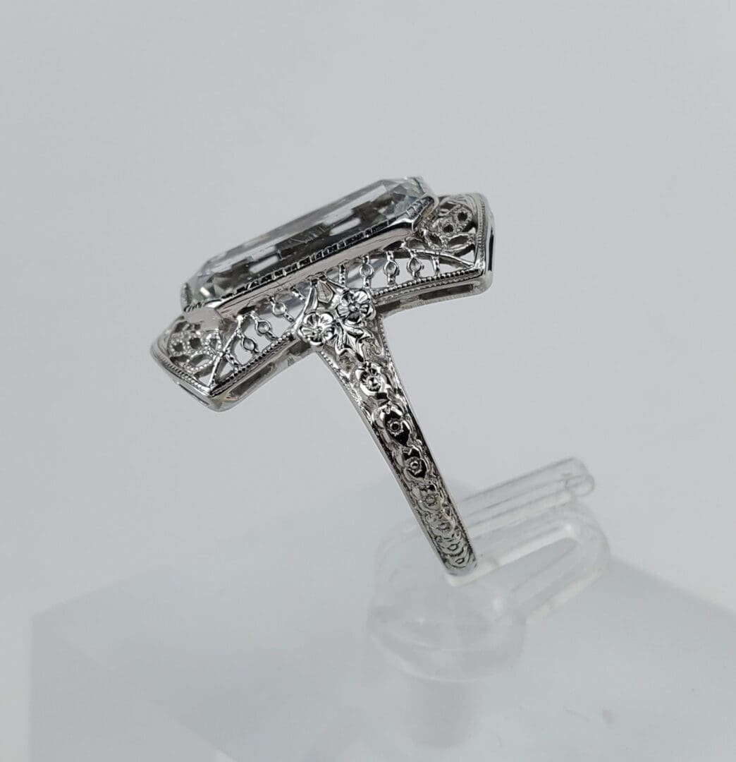 Ornate silver ring with rectangular gemstone.