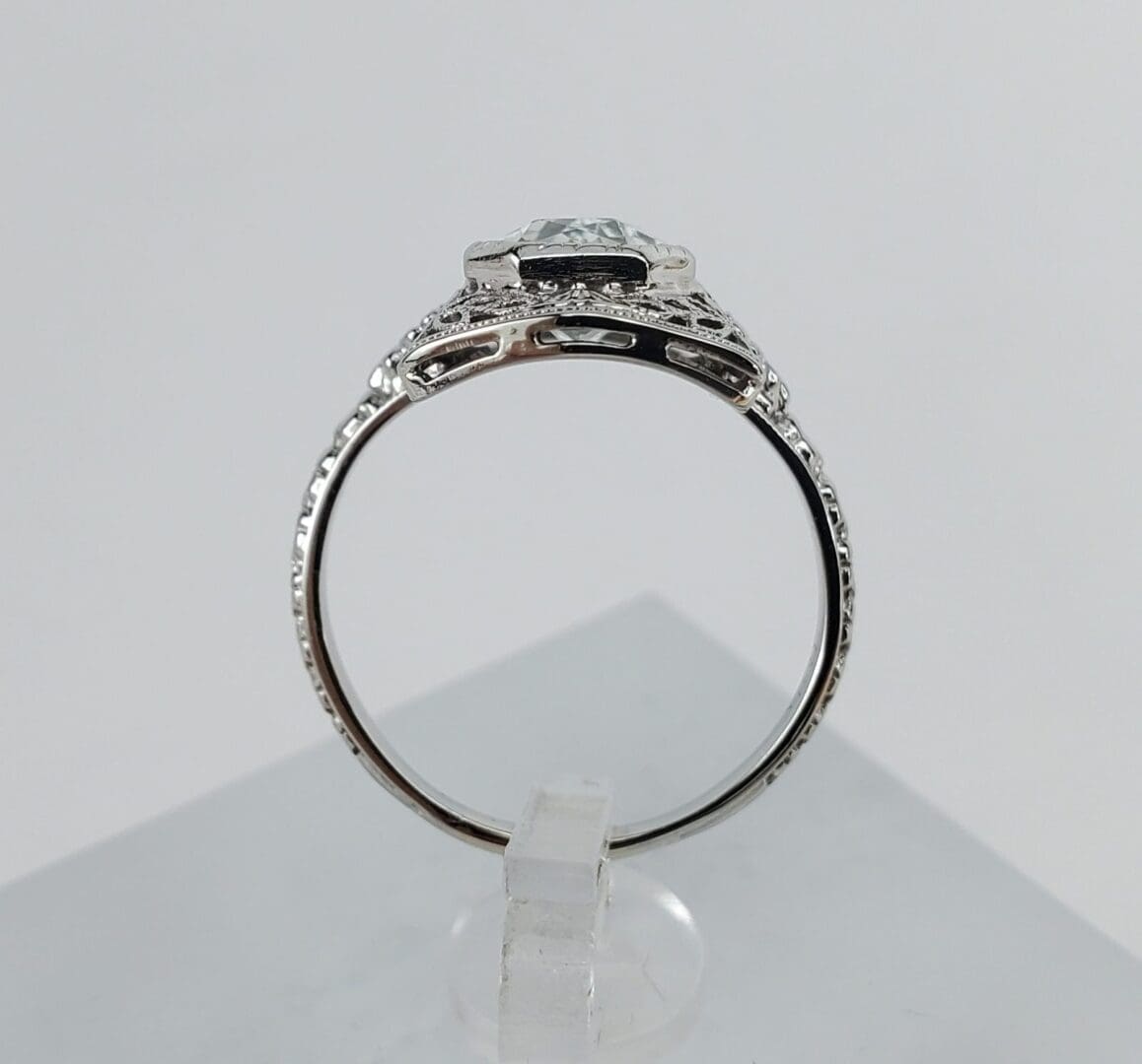 Silver ring with intricate detailing, side view.