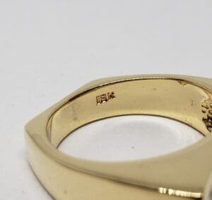 Gold ring with engraved markings inside band.