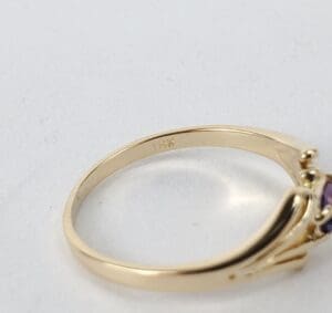 Gold ring with purple gemstone close-up.