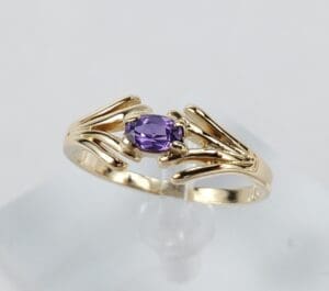Gold ring with a purple gemstone.