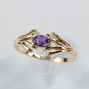 Gold ring with a purple gemstone.